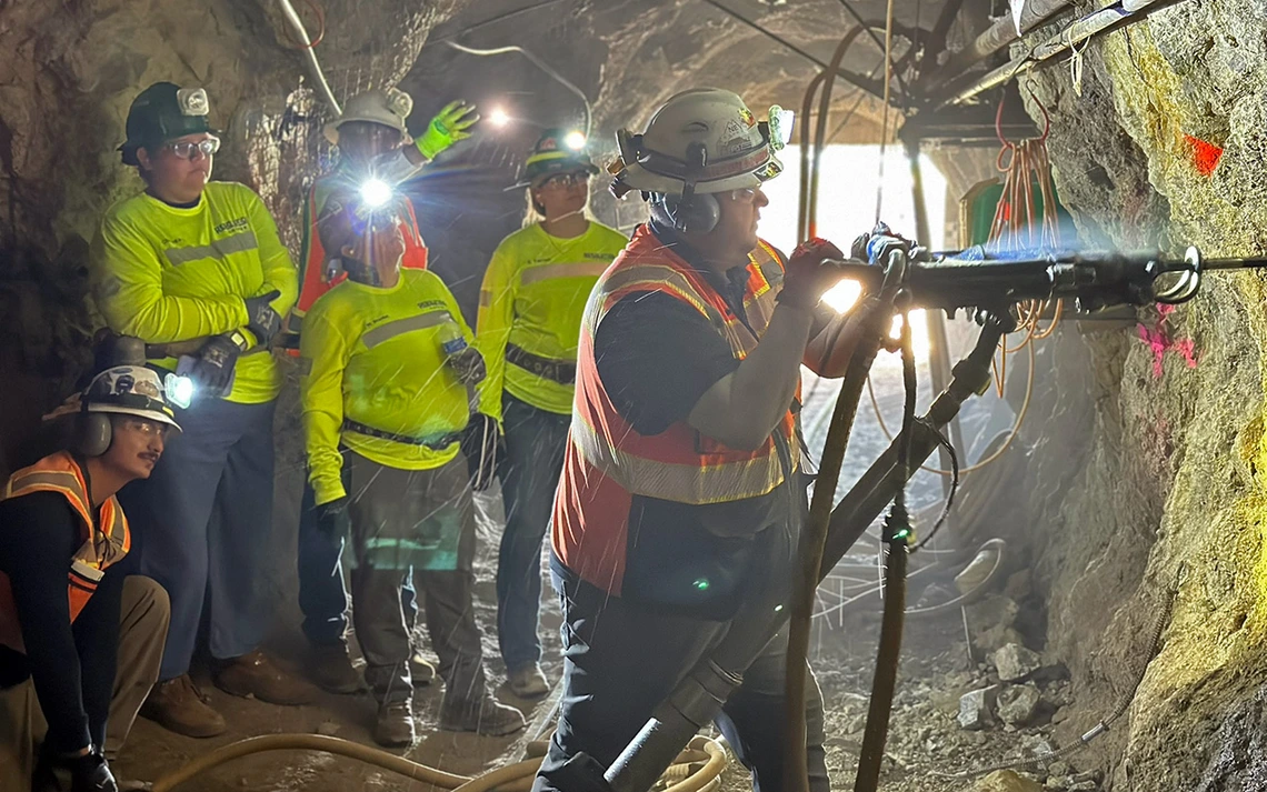 People in yellow suits inside a mine.