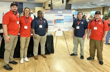 Group of students presenting their project poster